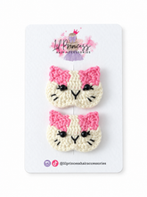 Reverse of crochet cat hair clips with pink bows, showing clip fastenings